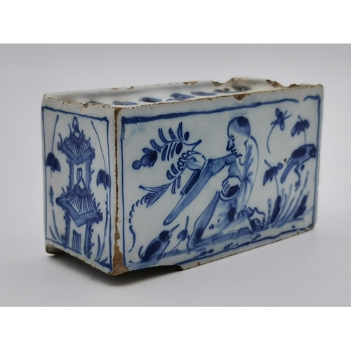 166 - A Delft blue and white flower brick, decorated with a kneeling figure and birds each side, a pagoda ... 