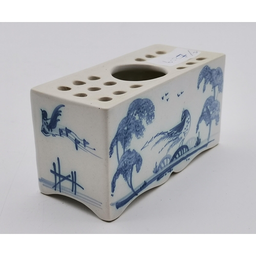 166 - A Delft blue and white flower brick, decorated with a kneeling figure and birds each side, a pagoda ... 