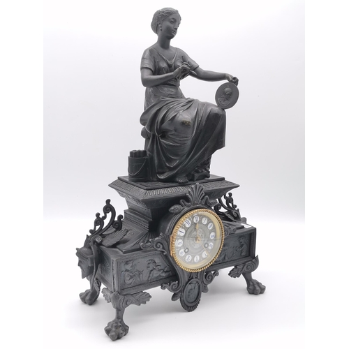 17 - A late 19th Century mantel clock surmounted with a seated female artist figure, cast with figural ma... 