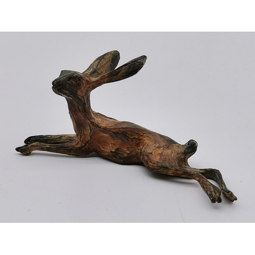 502 - A cold painted bronze hare, modelled lying down, by Michael Storey; together with a vintage small br... 