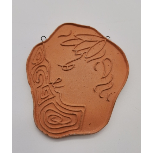 503 - Jean Cocteau (French, 1889-1963), A freeform terracotta pendant of a face in profile, the naturalist... 