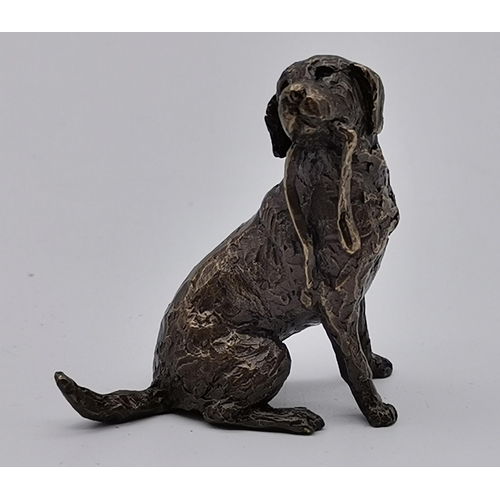 511 - A miniature bronze labrador figure by Butler and Peach, with soft pouch and box. 3.5cm high