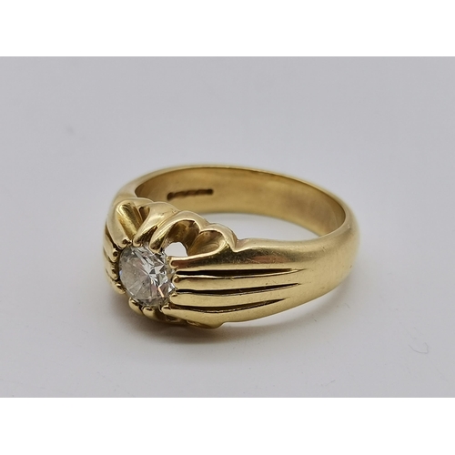 513 - A gent's 18 carat gold solitaire diamond ring, the single stone claw-set to pierced and reeded shoul... 