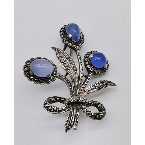 516 - An Elizabeth II silver marcasite and blue stone brooch, as a bow-tied floral spray, the three caboch... 