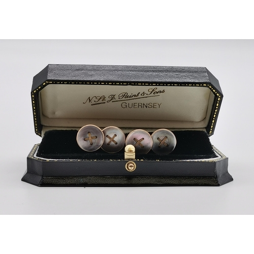 517 - A set of four 9 carat gold mother-of-pearl dress studs, early 20th Century, each as a shirt button w... 