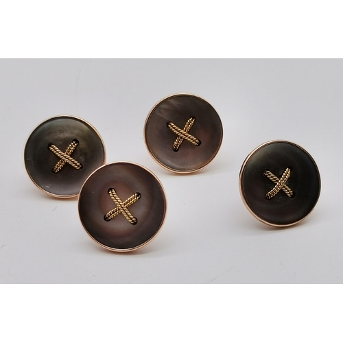 517 - A set of four 9 carat gold mother-of-pearl dress studs, early 20th Century, each as a shirt button w... 