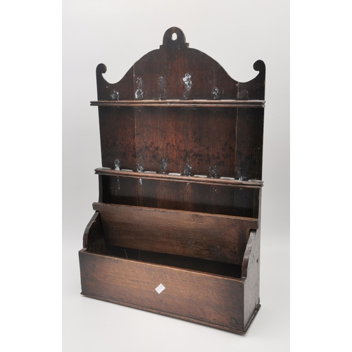 6 - A Georgian oak wall-hanging spoon rack with arched pediment, two rows of spoon holders over a lidded... 