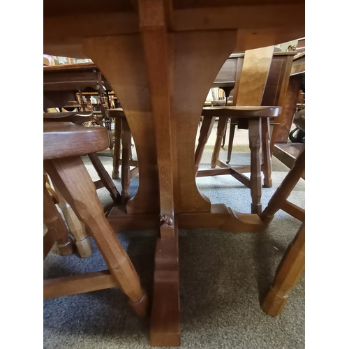 705 - Don Craven, a Foxman oak dining table, the adzed circular top raised on a cruciform base, with carve... 