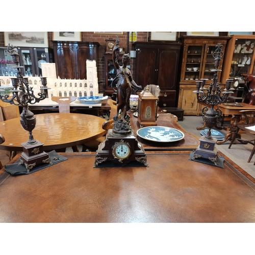 710 - A French marble and spelter clock garniture, 19th Century, the circular cream dial with black Arabic... 