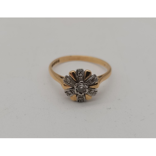 514A - An 18 carat gold cluster ring, set as a flowerhead, the central white stone enclosed by six white me... 