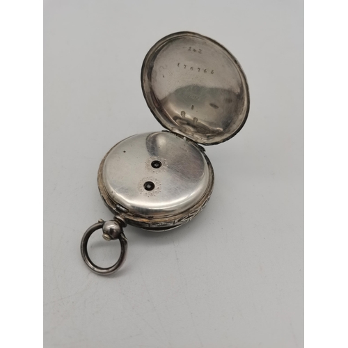 515a - A ladies silver pocket watch, highly engraved to rear of the case