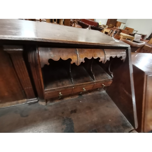 1198 - A Georgian oak bureau with bracket feet and decorative brass handles and a high decorative interior ... 