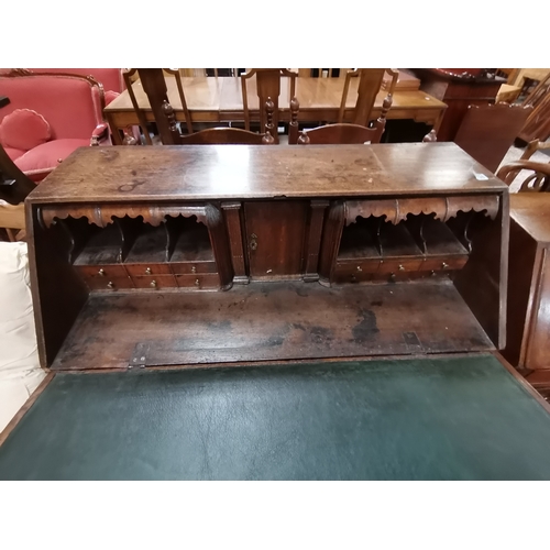 1198 - A Georgian oak bureau with bracket feet and decorative brass handles and a high decorative interior ... 