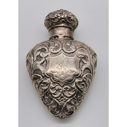 393 - A 19th Century silver cased scent bottle, marks heavily rubbed, heart shaped, chased all over with s... 