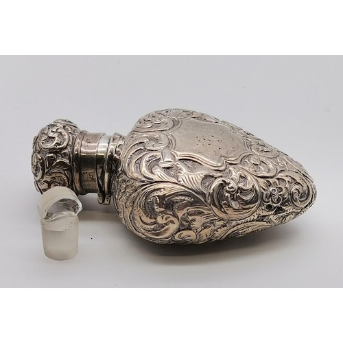 393 - A 19th Century silver cased scent bottle, marks heavily rubbed, heart shaped, chased all over with s... 