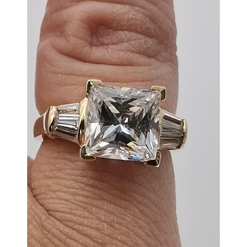 456 - A 14 carat gold white stone ring, the central square-cut cubic zirconia flanked by three baguette-cu... 