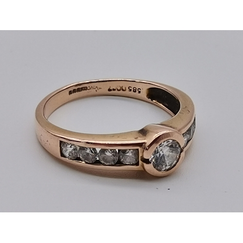 459 - A 14 carat rose gold nine stone ring, the central circular cubic zirconia flanked by four smaller ci... 