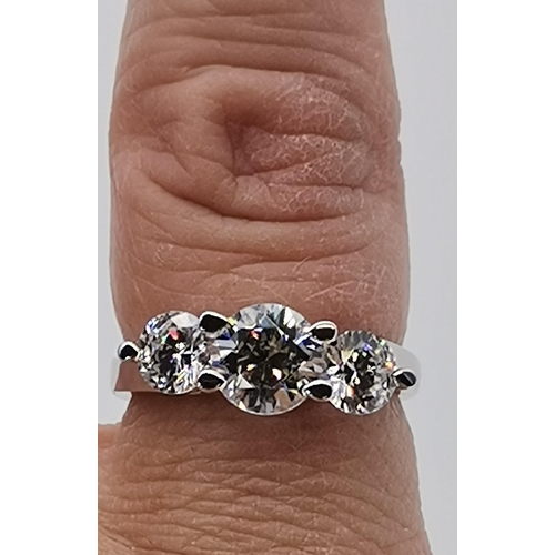 461 - A silver three stone ring, set with a trio of graduated circular cubic zirconias, stamped 925 and CZ... 