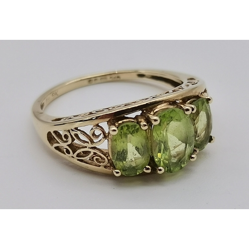 465 - A 9 carat gold three stone ring, set with a trio of graduated oval peridot stones in claw settings t... 