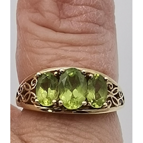 465 - A 9 carat gold three stone ring, set with a trio of graduated oval peridot stones in claw settings t... 