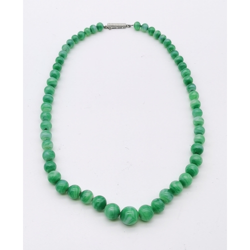 492 - A green jade necklace, mid-20th Century, the graduated spherical beads with swirling white inclusion... 