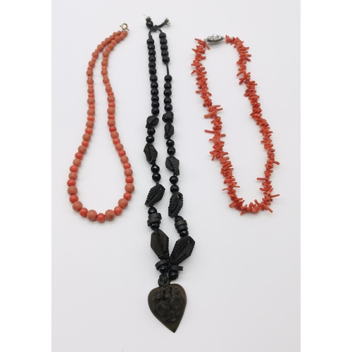 493 - A coral necklace, a coral and plastic bead necklace, and a faceted bead and carved wood necklace. (3... 