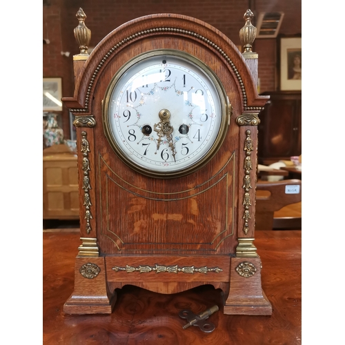 708 - Oak cased mantle clock with brass detailing with key and pendulum