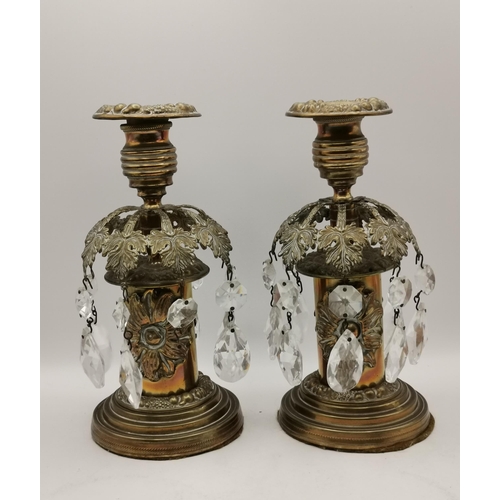 150 - A pair of brass candlesticks with pierced foliate decoration and glass drops; a pair of brass fighti... 