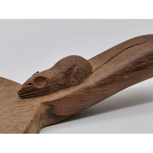 204 - Robert Thompson, a Mouseman oak cheese board, oval, with carved mouse signature to handle. 37cm long... 