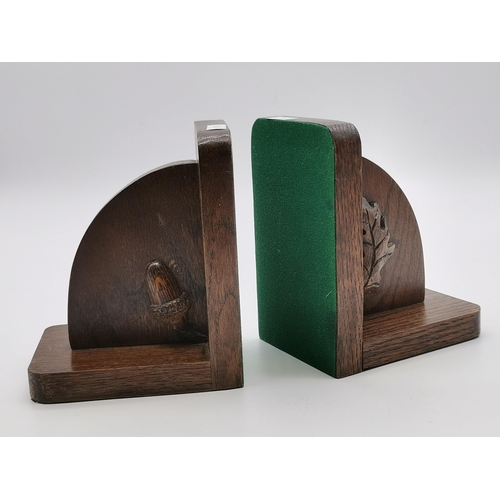 206 - A pair of carved oak bookends, one with an acorn, the other with an oak leaf. (2) 16cm high