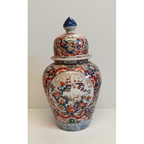 30 - A Pair of Imari Ribben Vases with Foo Dog Lids decorated with shield shapes enclosing floral designs... 