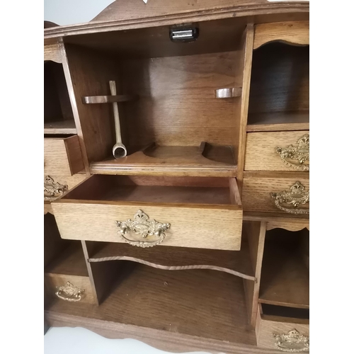 64 - An oak smoker's cabinet, early-mid 20th Century, the two part-glazed doors revealing a fitted interi... 