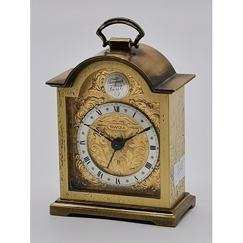 78 - A miniature brass cased alarm clock by Swiza, with engraved gilt metal face, the brushed steel chapt... 