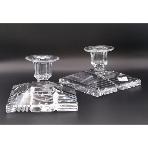 263 - A pair of pressed glass square candlesticks with decoratively sliced bases; together with a brass co... 