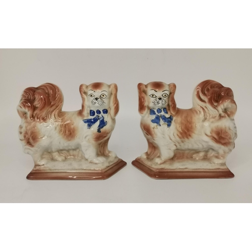 318 - A collection of Staffordshire dogs, comprising two pairs of Pekingese mantel dogs, a seated pug, and... 