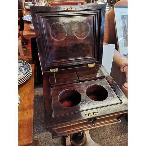 723 - An early Victorian rosewood teapoy, the sarcophagus form caddy with hinged cover carved with a band ... 