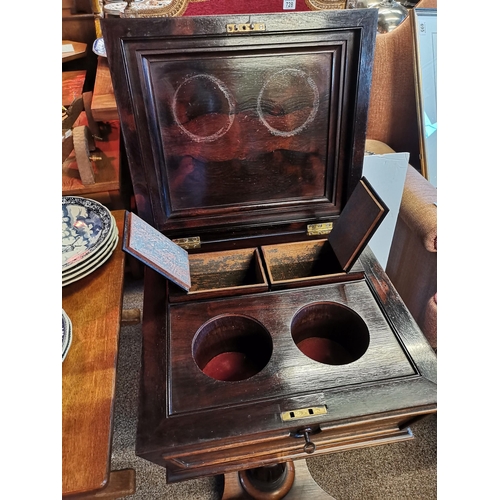 723 - An early Victorian rosewood teapoy, the sarcophagus form caddy with hinged cover carved with a band ... 