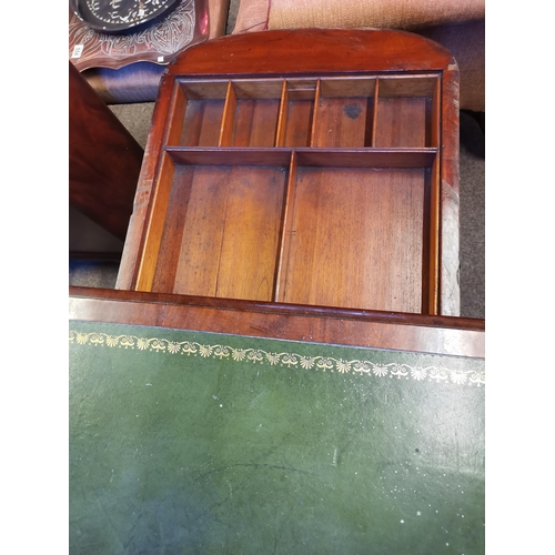 726 - A mahogany fold-over games table, the rounded rectangular top with inset gilt-tooled green leather w... 