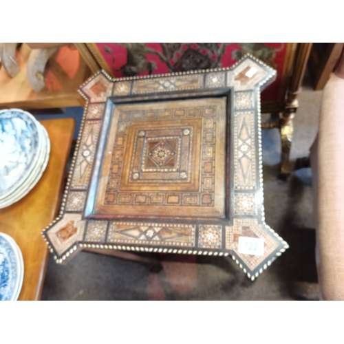 722 - A Moorish marquetry side table, square with ornate hardwood and ivory inlay, on stepped square legs ... 