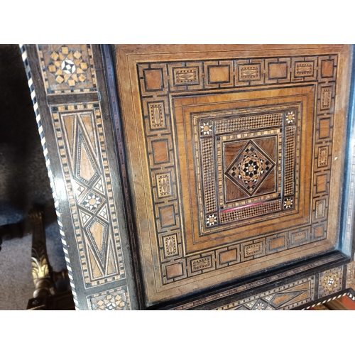 722 - A Moorish marquetry side table, square with ornate hardwood and ivory inlay, on stepped square legs ... 