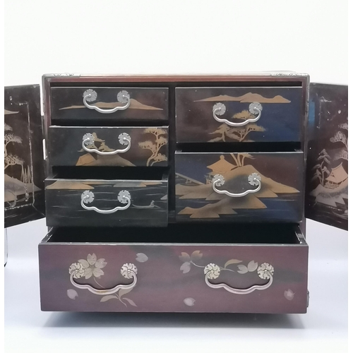 38 - An Oriental lacquered tabletop cabinet, a pair of doors over a deep drawer, five small drawers to th... 
