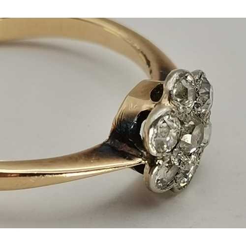 433A - An 18 carat gold and platinum white stone cluster ring, the seven round stones set as a flowerhead, ... 