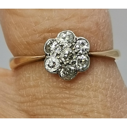 433A - An 18 carat gold and platinum white stone cluster ring, the seven round stones set as a flowerhead, ... 