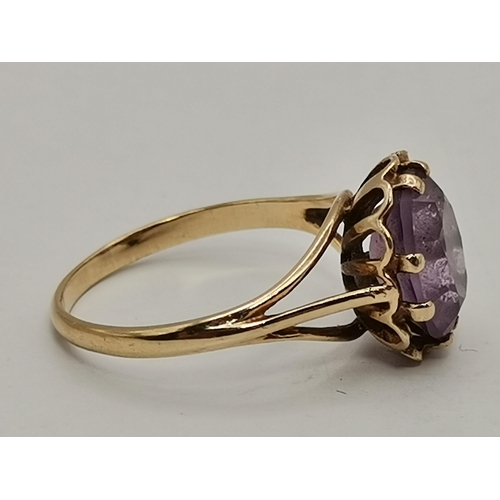 434A - Three 9 carat gold purple stone rings, the first claw-set with a cloudy oval stone to trifurcated op... 