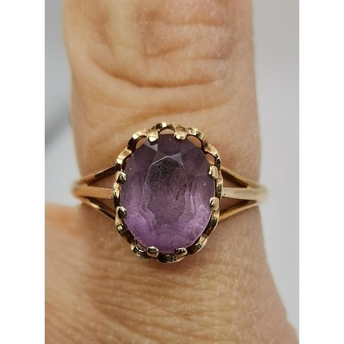 434A - Three 9 carat gold purple stone rings, the first claw-set with a cloudy oval stone to trifurcated op... 