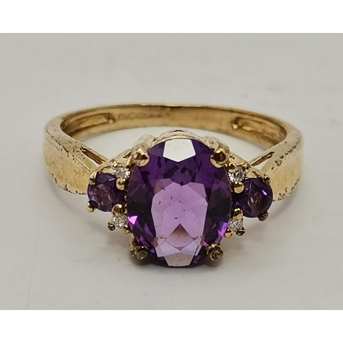 434A - Three 9 carat gold purple stone rings, the first claw-set with a cloudy oval stone to trifurcated op... 