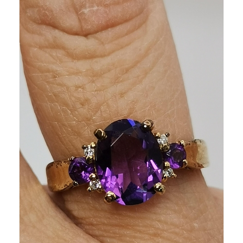 434A - Three 9 carat gold purple stone rings, the first claw-set with a cloudy oval stone to trifurcated op... 