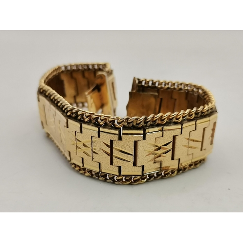 444 - A 9 carat gold hinge-opening bangle, engraved to front with scrolling foliate decoration, stamped 9C... 