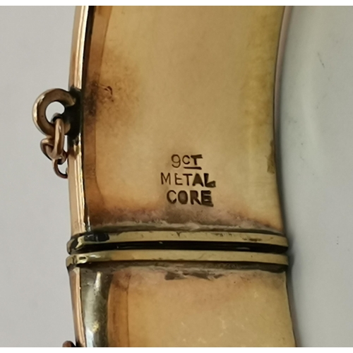 444 - A 9 carat gold hinge-opening bangle, engraved to front with scrolling foliate decoration, stamped 9C... 