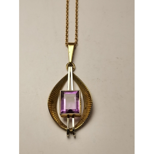 444A - A 9 carat gold gem-stone pendant, set with a rectangular purple stone to twin vertical white gold ba... 